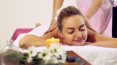 Rahat bir kadın profesyonel masaj terapistiyle lüks kaplıcalarda masaj yaptırıyor. Sağlık, şifa ve rahatlama konsepti.