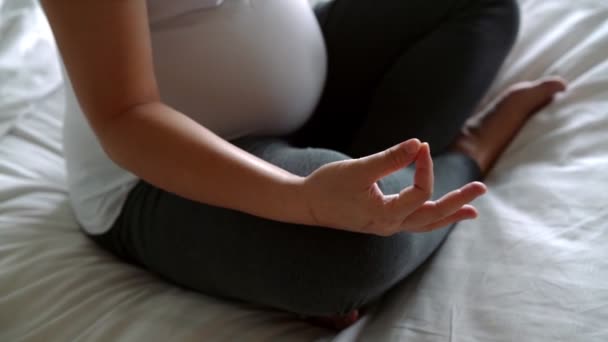 孕妇在家里的卧室里做瑜伽运动 同时照顾孩子 快乐的年轻孕妇在怀孕的肚子里抱着孩子 产前护理和怀孕 — 图库视频影像