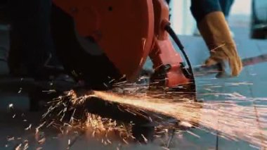Profesyonel tamirci çelik metali dönen elmas kesici ile kesiyor. Çelik endüstrisi ve atölye konsepti.