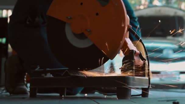 プロのメカニックは 回転ダイヤモンドブレードカッターで鋼金属を切断しています 鉄鋼業とワークショップのコンセプト — ストック動画