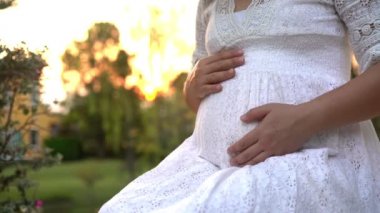 Hamile bir kadın, çocuğuna bakarken bahçe evinde mutlu bir hayat yaşıyor. Hamile karnında bebek taşıyan hamile bir anne. Doğum öncesi bakım ve kadın hamileliği konsepti.