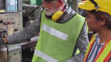 Fabrika atölyesinde makine ekipmanı kullanan bir grup işçi.