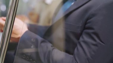Trende cep telefonu kullanan gezgin yüz maskesi takıyor