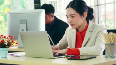 Modern ofis odasındaki masada çalışan iş adamları mali veri raporlarını incelerken .