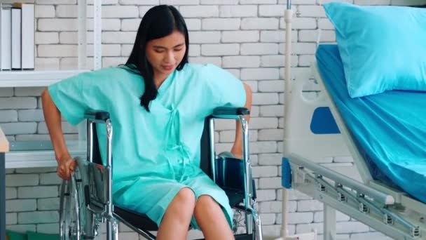 Joven mujer asiática feliz en silla de ruedas en un hospital — Vídeo de stock