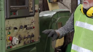 Fabrika işçisi fabrika atölyesinde makine teçhizatı kullanmayı öğretiyor.