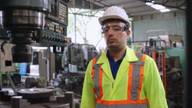 Fabrika atölyesinde makine kullanan akıllı bir fabrika işçisi