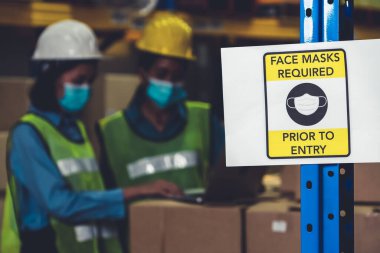 Fabrika işçileri için uyarı işareti Covid-19 'u önlemek için