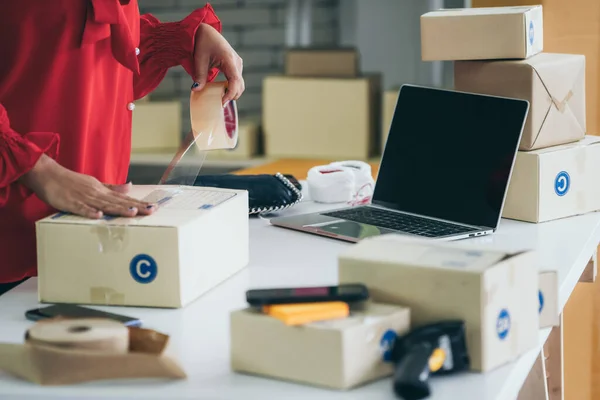 El vendedor en línea trabaja en la oficina de casa y empaca la caja de envío al cliente. — Foto de Stock