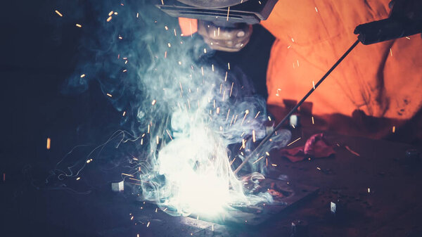 Metal welder working with arc welding machine