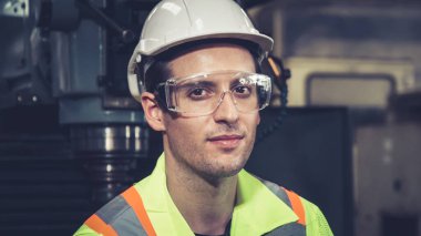 Genç bir fabrika işçisi ya da mühendis fabrikada portreyi kapatıyor.