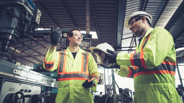 공장 근로자는 직장 동료에게 안전에 대해 경고하고 단단 한 모자를 씌워 준다 — 스톡 사진