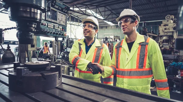 Factory workers handshake with team member in the factory