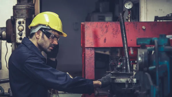 Fabrika işçisi, makine parçalarını incelerken taşınabilir radyodan konuşuyor. — Stok fotoğraf