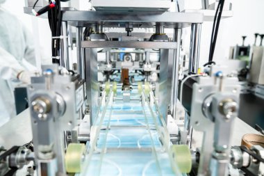 Modern fabrikada yüz maskesi üretim hattı