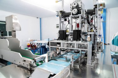 Modern fabrikada yüz maskesi üretim hattı