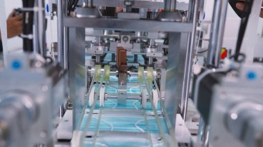 Modern fabrikada yüz maskesi üretim hattı