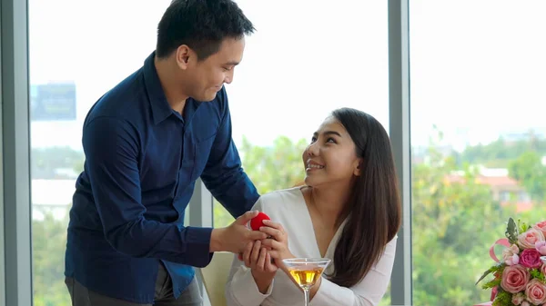 Romantic couple giving gift to lover at restaurant — Stock Photo, Image