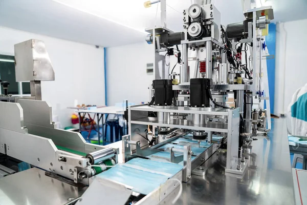 Modern fabrikada yüz maskesi üretim hattı