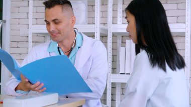 Profesyonel üniformalı doktor hastanedeki hastayı muayene ediyor.