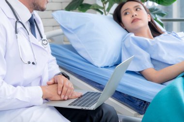 Profesyonel üniformalı doktor hastanedeki hastayı muayene ediyor.