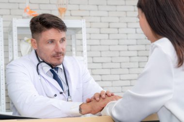 Profesyonel üniformalı doktor hastanedeki hastayı muayene ediyor.