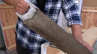 Marangoz atölyede ahşap işçiliği yapıyor.