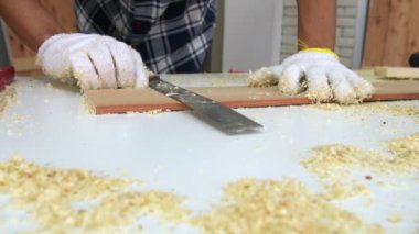 Marangoz atölyede ahşap işçiliği yapıyor.