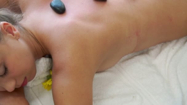 Tratamiento de masaje con piedras calientes por terapeuta en spa. — Vídeos de Stock