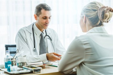 Profesyonel üniformalı doktor hastanedeki hastayı muayene ediyor.