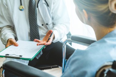 Profesyonel üniformalı doktor hastanedeki hastayı muayene ediyor.