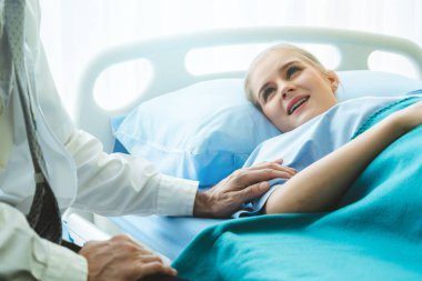Profesyonel üniformalı doktor hastanedeki hastayı muayene ediyor.