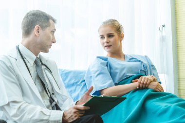 Profesyonel üniformalı doktor hastanedeki hastayı muayene ediyor.