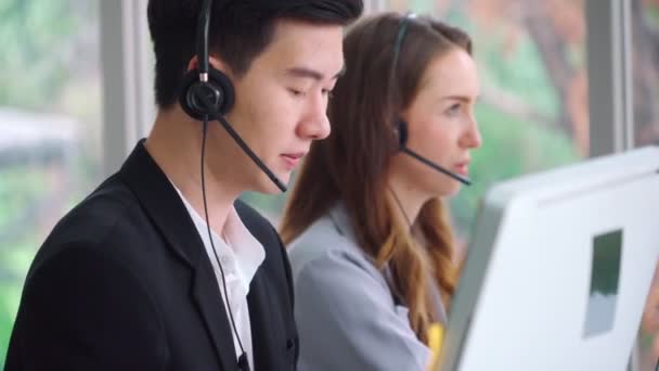 Επιχειρηματίες που φορούν ακουστικά και εργάζονται στο γραφείο — Αρχείο Βίντεο