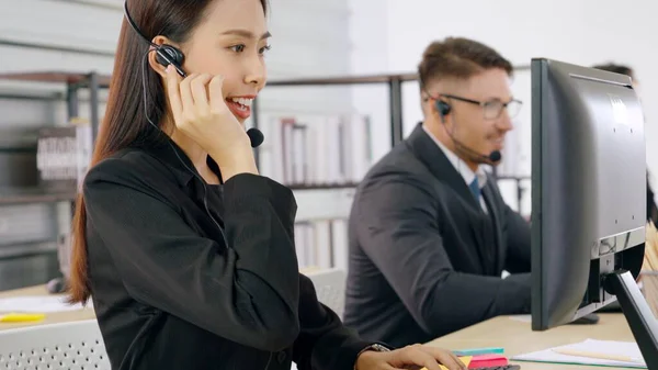 Zakenmensen met een koptelefoon aan het werk — Stockfoto