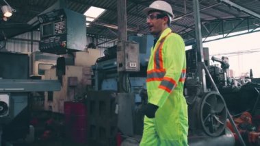 Fabrika işçileri fabrikadaki ekip üyeleriyle tokalaşıyor.