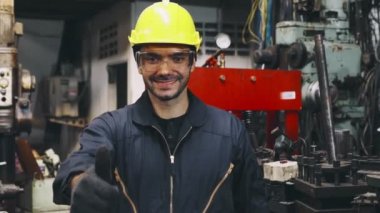 Genç bir fabrika işçisi ya da mühendis fabrikada portreyi kapatıyor.