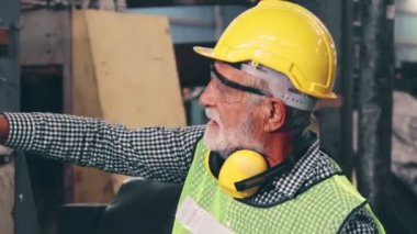 Fabrika işçisi fabrika atölyesinde makine teçhizatı kullanmayı öğretiyor.