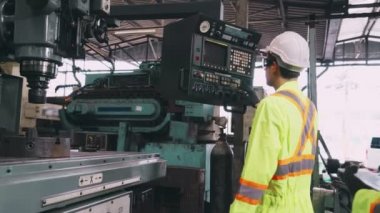 Fabrika atölyesinde makine ekipmanı kullanan bir grup işçi.