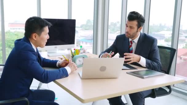 Két üzletember megbeszéli a projektstratégiát az irodában. — Stock videók