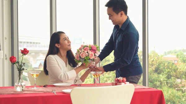 Romantic couple giving gift to lover at restaurant — Stock Photo, Image