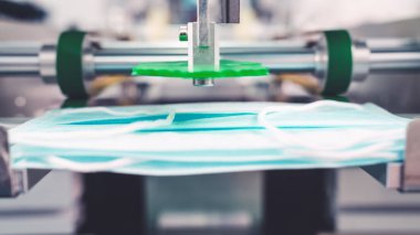 Modern fabrikada yüz maskesi üretim hattı