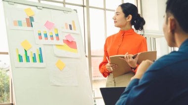 Genç kadın iş verilerini beyaz tahtada açıklıyor