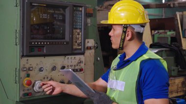 Fabrika atölyesinde makine kullanan akıllı bir fabrika işçisi
