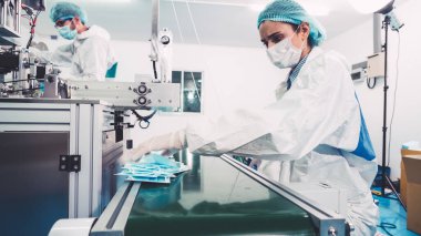 Modern fabrikada yüz maskesi üretim hattı