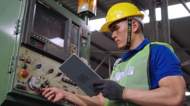 Fabrika atölyesinde makine kullanan akıllı bir fabrika işçisi