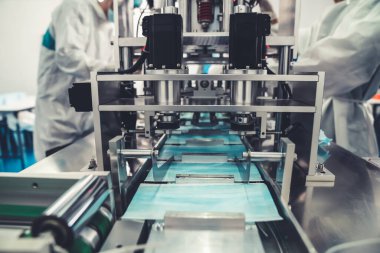 Modern fabrikada yüz maskesi üretim hattı