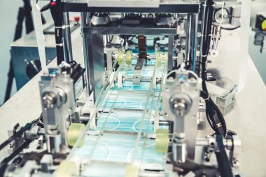 Modern fabrikada yüz maskesi üretim hattı