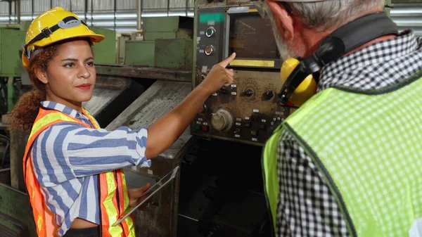 Group of factory workers using machine equipment in factory workshop