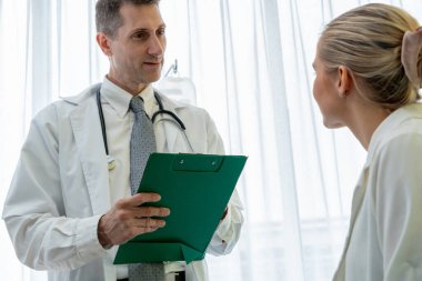 Profesyonel üniformalı doktor hastanedeki hastayı muayene ediyor.